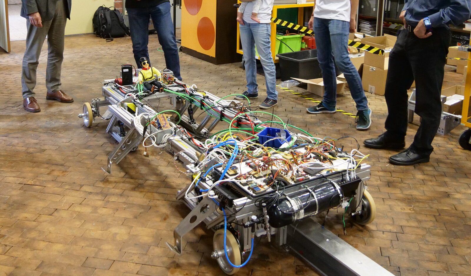 The open XPod chassis on an aluminium test rail — levitation frames, pneumatics, batteries, and wiring exposed during integration testing